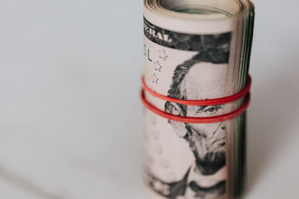 Immagine di un rotolo di banconote da un dollaro, che rappresenta la ricchezza e la moneta finanziaria.
